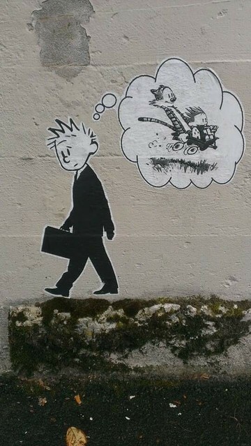 Unter Verwendung von "Calvin & Hobbes" (Comic) : Ein erwachsener Calvin mit Anzug und Aktentasche geht mit traurigem entweder zur Arbeit oder von der Arbeit. Über seinem gesenkten Kopf ist eine Denkblase, in der das Kind Calvin und der Tiger Hobbes mit lachenden Gesichtern in einem Bollerwagen einen Berg herunter rasen.