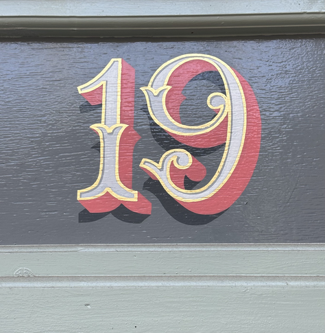 Lovely hand painted typographical detail on the cake shop, with gold outline on the number 19