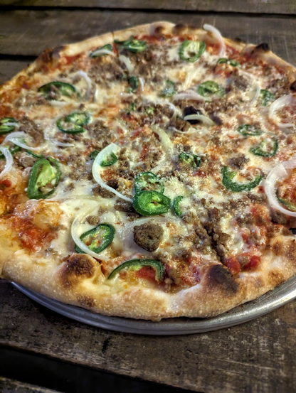 A 14-inch pizza with red sauce, mozzarella, sausage, onion, and jalapeño